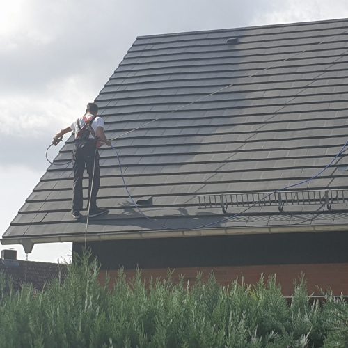 Person beschichtet Dach neu